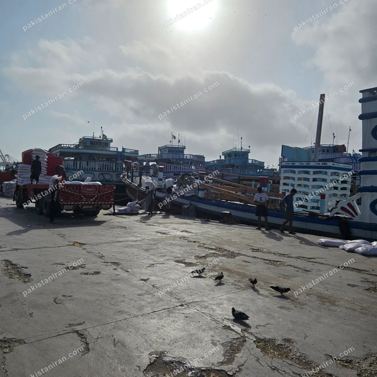 HAS Trading shipment: Bagged rice trucked onto the Karachi wharf, launches moored alongside